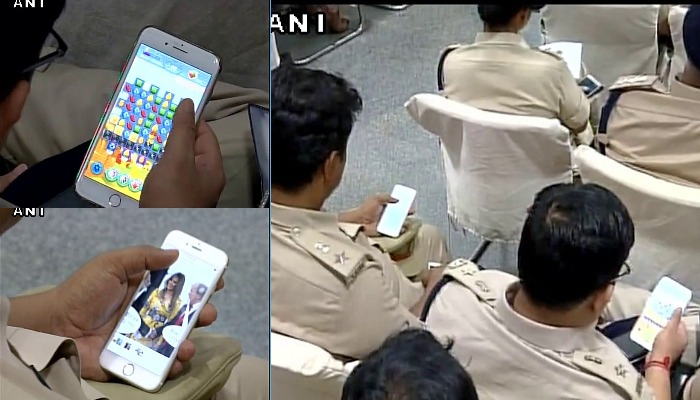 मुख्यमंत्र्यांच्या भाषणादरम्यान पोलीस अधिकारी मेलानिया ट्रम्पचा फोटे पाहण्यात दंग मुख्यमंत्र्यांच्या भाषणादरम्यान पोलीस अधिकारी मेलानिया ट्रम्पचा फोटे पाहण्यात दंग